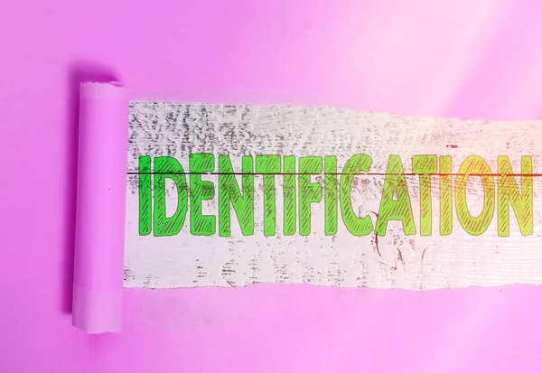 Textzeichen mit Identifikation. Konzeptfoto, das die Identität einer Person in Form offizieller Papiere beweist, gerollte zerrissene Pappe, die über einer klassischen Tischkulisse aus Holz platziert wurde. — Stockfoto