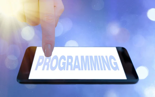 Conceptual hand writing showing Programming. Business photo showcasing the process of preparing an instructional program for a device Modern gadgets white screen under colorful bokeh background.