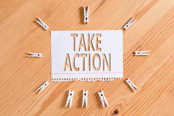 Take Action 'ı gösteren kavramsal el yazısı. Özel bir sonuç elde etmek için bir şeyler yapmak ya da yapmak için iş fotoğrafı sergisi. Renkli buruşmuş kağıtlar. Ahşap zemin çamaşır mandalı..