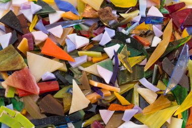 Tüm şekil ve boyutlarda dağınık ve neşeli, eğlenceli benzersiz parlak arka plan dokusu içinde üst üste parlak renkli vitray Close-up fişleri