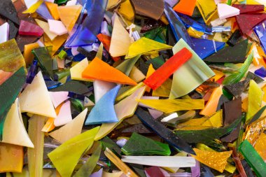 Tüm şekil ve boyutlarda dağınık ve neşeli, eğlenceli benzersiz parlak arka plan dokusu içinde üst üste parlak renkli vitray Close-up fişleri