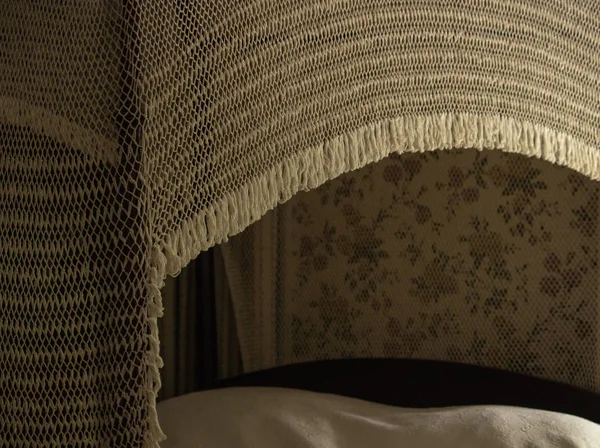 Ivory, white crocheted 1800s antique canopy over vintage bed, romantic decor illustrates elegance in retro, Victorian era