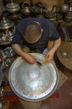 Gaziantep, Türkiye - 07 Haziran 2014: Sanatçı, Türkiye 'nin Gaziantep kentindeki Bakirye Çarşısı' nda bakır tepside çalışıyor.