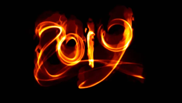 Feliz año nuevo 2019 letras números aislados escritos con llama de fuego blanco o humo sobre fondo negro — Foto de Stock