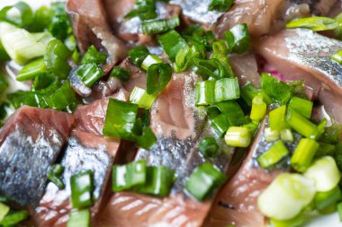 Ringa balığı yeşil soğan ile bir tabağa dilimlenmiş. Seçici odak makro ile sığ Dof vurdu.