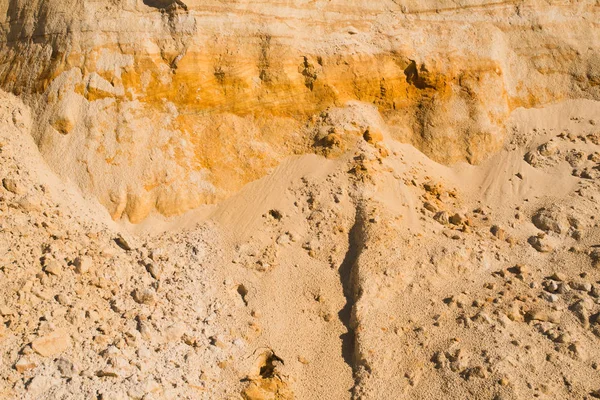 Скала желтого оранжевого коричневого песка глины почвы под ярким солнечным днем. Текстурный фон — стоковое фото