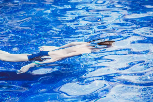 Mladý muž plavání v bazénu pod vodou — Stock fotografie