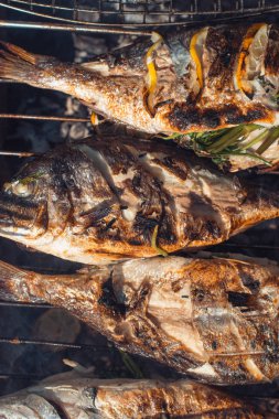 Yaz bahçesinde barbekü ızgara üzerinde limonlu ızgara balık