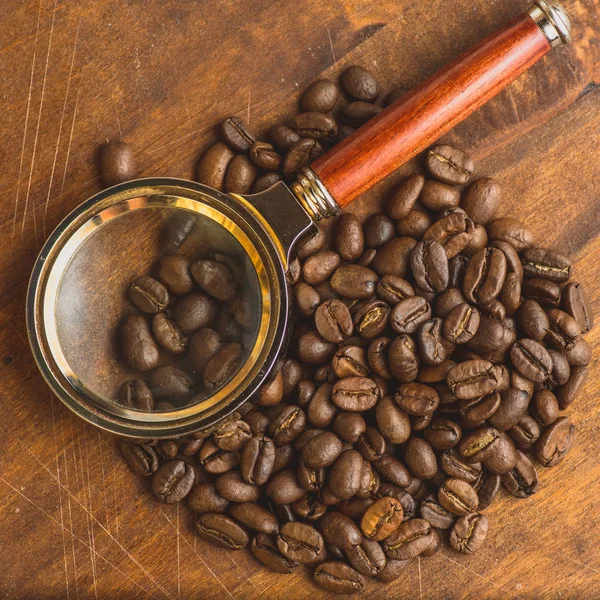 원형 모양, 배경과 텍스처에 대 한 매크로 커피 콩의 갈색 커피 콩. 에 갈색 나무 보드 확대 유리. Copyspace — 스톡 사진