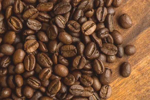 원형 모양, 배경과 텍스처에 대 한 매크로 커피 콩의 갈색 커피 콩. 갈색 나무 보드에. — 스톡 사진
