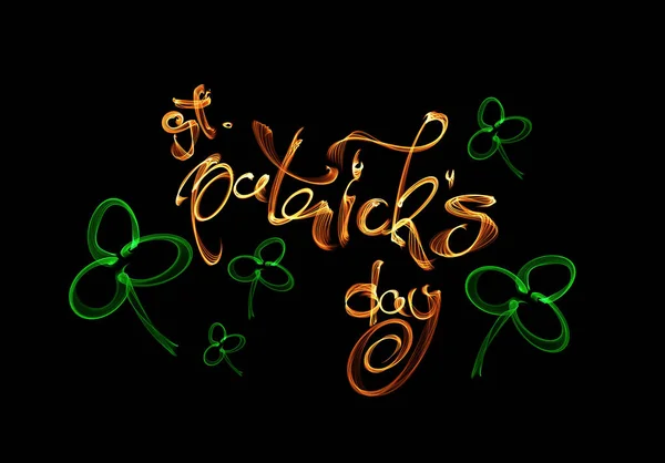 Elegant greeting card design with creative shiny lettering calligraphy text Happy St. Patricks Day made of fire flame or smoke isolated on black background — Stock Photo, Image