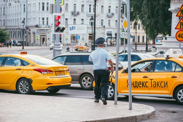 Moskou, Russin Federatie - 28 juli 2017: De inspecteur politieman gestopt Yandex taxichauffeur, in Moskou in Rusland zomerseizoen - afbeelding — Stockfoto