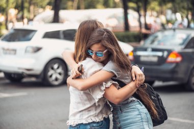 Anne ve kızı arabalar ve yoğun trafik olan yol arka planı sarılma güneş gözlüğü ile