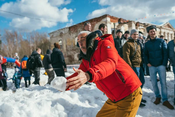 REGIÓN DE MOSCÚ, FRYAZINO, GREBNEVO ESTATE - 09 DE MARZO DE 2019: Larbi Bibi Naceri Estrella, actor y director francés jugando bolas de nieve con niños locales que visitan la finca Grebnevo durante la celebración de Maslenitsa — Foto de Stock