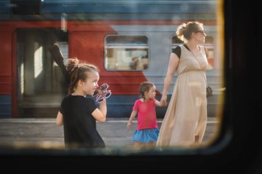 Moskova Rusya - 27 Temmuz 2017. Tren penceresinden görüntüleyin. aile anne ve iki kızı, Domodedovo açık bir anne kime tren kapıları ile arka planda elinden tutar
