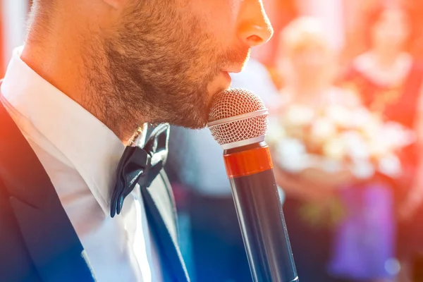 Profil sahibi Konuklar bulanık bir zemin üzerine onun elinde bir mikrofon ile yakışıklı bir adam. O bir siyah ceket, beyaz gömlek ve kravat giymiş. Seminer toplantı, iş olay veya düğün