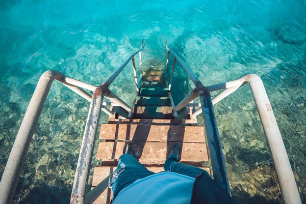 Oude vintage metalen houten trap die leidt naar blauw turquoise zee water van strand. Mooie zomerdag. Zwembad met grunge retro trappen op de Oceaan kust. Bovenaanzicht Pov — Stockfoto