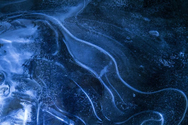 Réseau de fissures dans une épaisse couche de glace solide gelée avec une lumière brillante — Photo