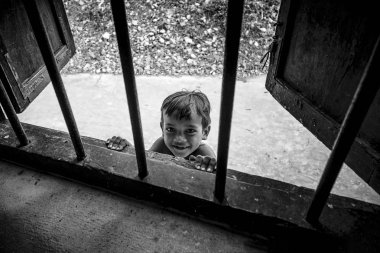 Lolei, Kamboçya - 01 Ocak 2017: Wat Lolei Budist Tapınağı'nda pencereden bakarak bir meraklı çocuk