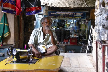 Madurai, Hindistan - 23 Ağustos 2018: Dükkânının önünde bir dikiş makinesi Mandapam pazarında oturan bir terzi
