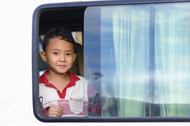 Phnom Penh, Kamboçya - 30 Aralık 2018: Phonm Penh, Kamboçya'nın başkenti sokakta arabasının pencereden dışarı bakarak şirin küçük bir çocuk 