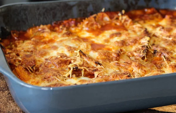 Hornear lasaña italiana hecha a sí mismo, con mozzarella en el horno en la cocina —  Fotos de Stock