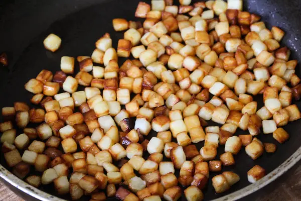 Gebakken aardappelblokjes in pan in keuken — Stockfoto