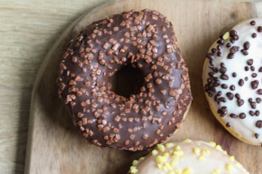 ahşap bir arka plan üzerine serpinti ile tek çikolata donut