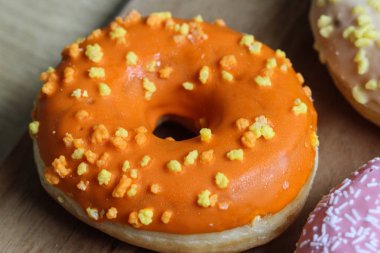 ahşap bir arka plan üzerinde serpinti ile tek turuncu donut