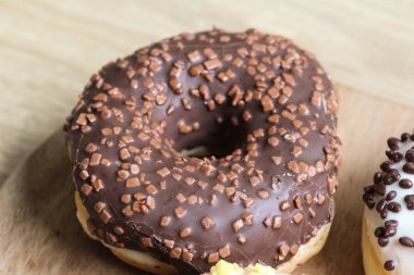 ahşap bir arka plan üzerine serpinti ile tek çikolata donut