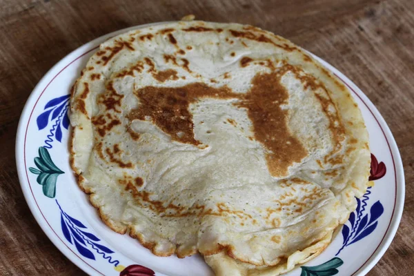 Färska själv bakade naturliga tomma pannkakor på en vit tallrik på en trä bakgrund — Stockfoto