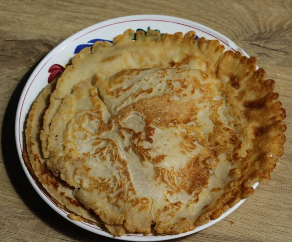 Frische selbstgebackene, natürliche leere Pfannkuchen auf einem weißen Teller auf einem hölzernen Hintergrund — Stockfoto