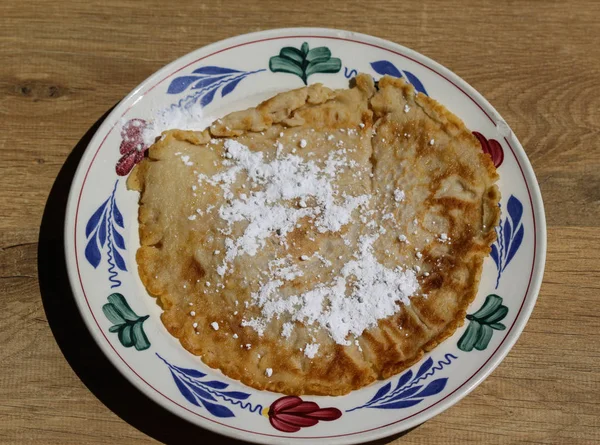 Nybakad pannkaka med strösocker på plattan på trä bakgrund — Stockfoto