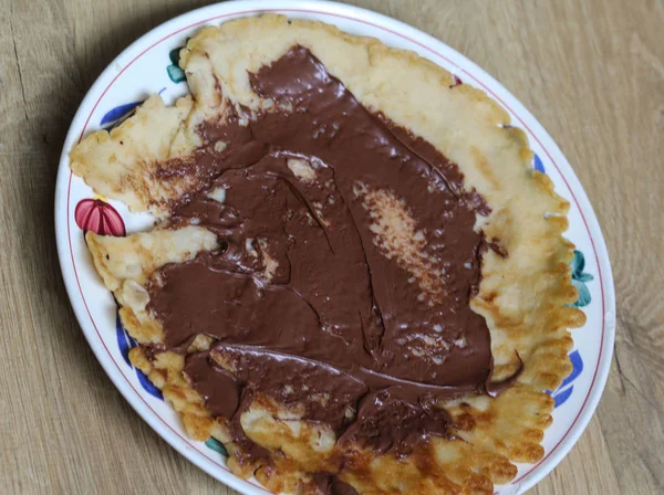 Pannkaka på tallrik med choklad pasta på trä bakgrund — Stockfoto