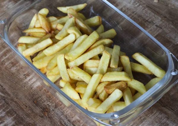 Sabrosas papas fritas caseras en plato blanco, sobre fondo de mesa de madera — Foto de Stock