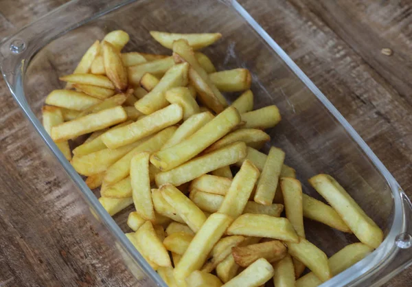 Gustose patatine fritte fatte in casa su piatto bianco, su sfondo tavolo di legno — Foto Stock