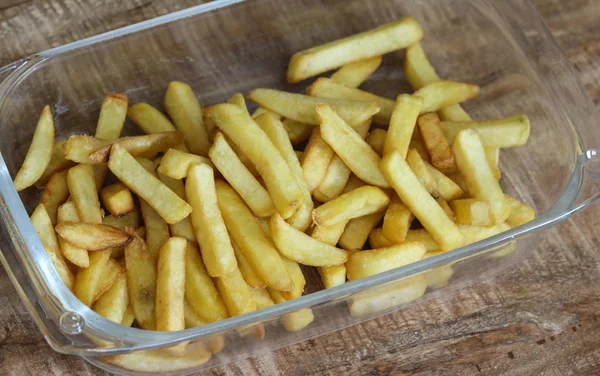 Sabrosas papas fritas caseras en plato blanco, sobre fondo de mesa de madera — Foto de Stock