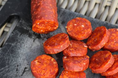 Taze yapılmış İspanyol domuz chorizo sosis kırmızı biber, sarımsak, biberiye ve biberiye ile yapılan, siyah bir kesme tahtası üzerinde dilimlenmiş