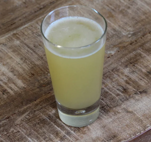 Glas gefüllt mit Radler, Mischung aus Bier und prickelnder Limonade, auf Holzgrund — Stockfoto