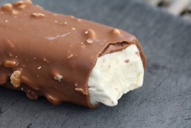 Siyah arka plan üzerinde Vanilyalı sütlü çikolata badem bar dondurma