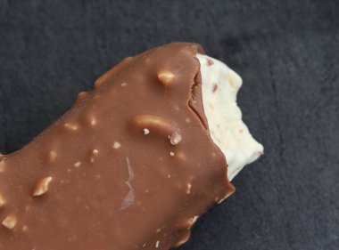 Siyah arka plan üzerinde Vanilyalı sütlü çikolata badem bar dondurma