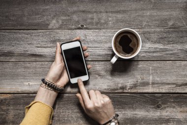 Kadın el telefon boş ekran üzerinde ahşap tablo kullanma
