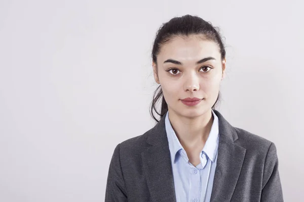 Gri arka plan üzerinde genç iş kadını