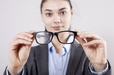 Gözlük gri arka plan üzerinde elinde tutan işkadını