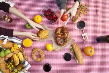 Çimenlerin üzerinde Parkta piknik: masa örtüsü, sepet, sağlıklı yiyecek ve aksesuarları, üstten görünüm