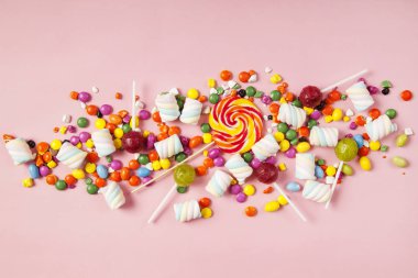 Renkli lolipoplar ve farklı renkte yuvarlak şekerler. Üst görünüm.