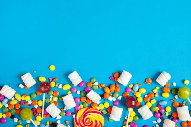 Renkli lolipoplar ve farklı renkte yuvarlak şekerler. Üst görünüm.