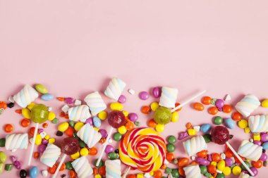 Renkli lolipoplar ve farklı renkte yuvarlak şekerler. Üst görünüm.
