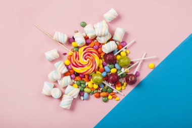 Renkli lolipoplar ve farklı renkte yuvarlak şekerler. Üst görünüm.