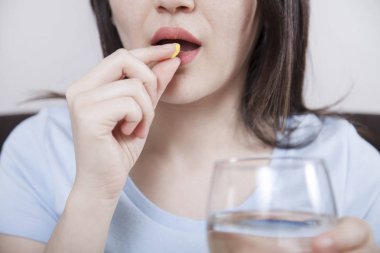 Genç kadın hap alıyor.